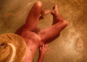 A Sunny Day At The Golden Beach utstrålar lugn, värme och somrig frihet. En naken man vilar avslappnat på den gyllene stranden